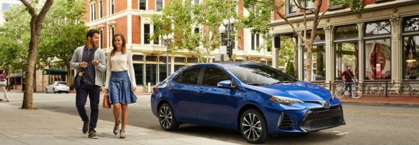 2019 Toyota Corolla parked curbside as two people walk past